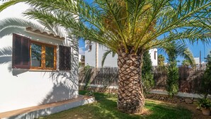 A white building with a stone pillar and a palm tree in the yard. - Casa Hector - Villa With Private Pool In Cala D'or (Cala D'or, Illes Balears)