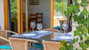 An outdoor dining area with wicker chairs and tables set for two, each with a wine glass. - Casa Hector - Villa With Private Pool In Cala D'or (Cala D'or, Illes Balears)