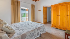 A bedroom with a bed, a wardrobe, and a door leading to a balcony. - Cas Consul - Villa With Private Pool. Free Wifi (Sant Miquel De Balasant, Illes Balears)
