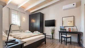 A bedroom with a bed, bedside table, desk, chair, TV, wardrobe, and a window with curtains. - Finca Son Colom (finca Sun Club Home) - Villa (Llucmajor, Illes Balears)