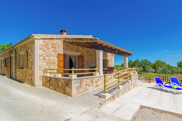 A stone building with a covered porch and outdoor seating area. - S'aresta Den Rumbet - Villa With Private Pool (Llucmajor, Illes Balears)