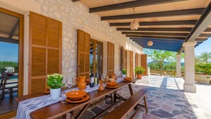An outdoor dining area with stone flooring, wooden tables, and benches. - Son Roca - Villa With Private Pool In Montuïri (Montuïri, Illes Balears)