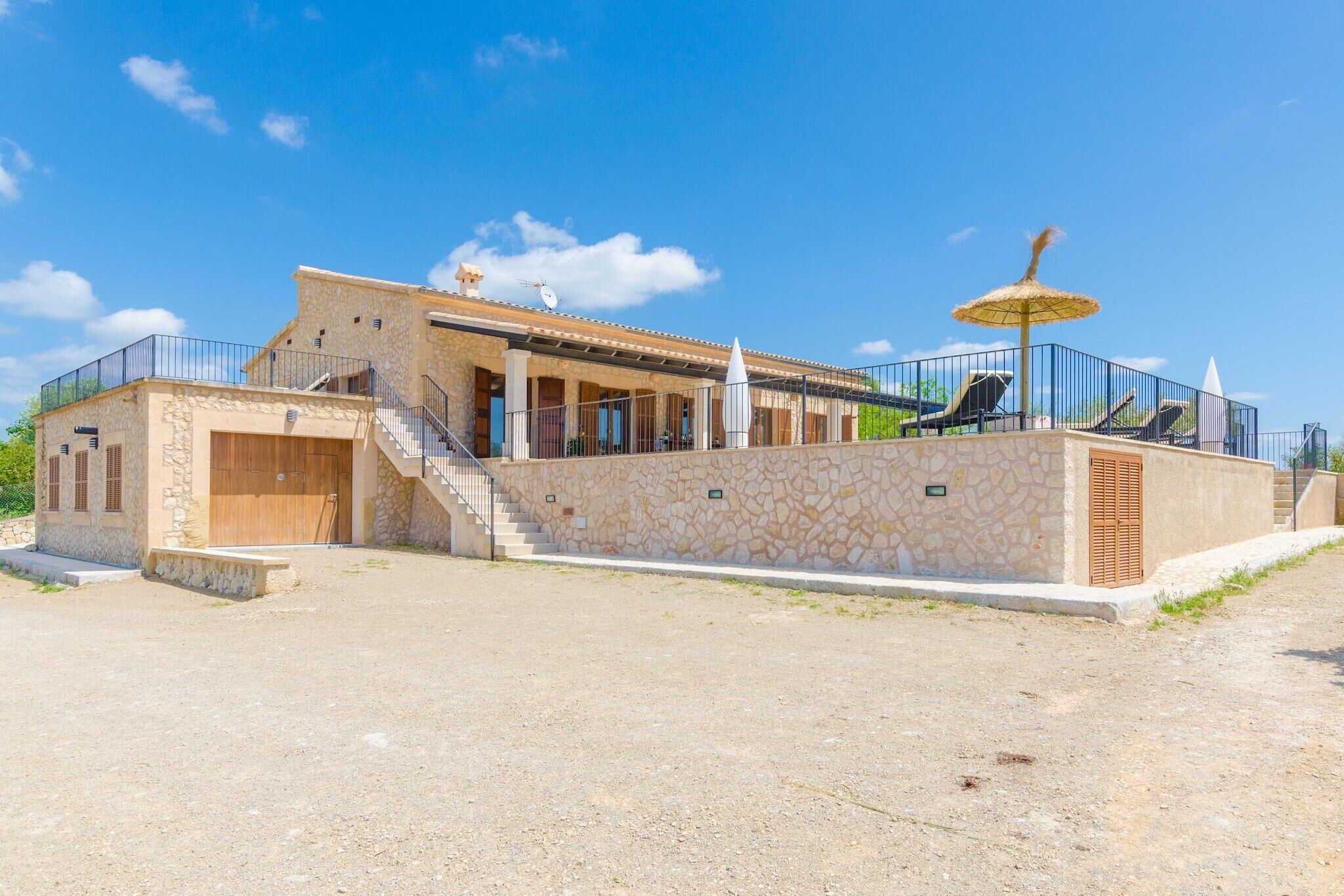 Un bâtiment en pierre doté d’un balcon, d’un escalier et d’un espace de repos abrité.