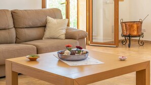 A living room with a beige sofa, a wooden coffee table, and a metal bowl with flowers and candles. - Son Roca - Villa With Private Pool In Montuïri (Montuïri, Illes Balears)