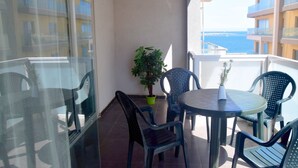 A balcony with a table and chairs, a potted plant, and a view of the sea. - Amazing and Spacious Apartmet wSide Sea View (San Pawl il-Baħar)