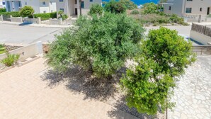 A residential area with modern houses, a paved driveway, and a view of the sea. - Dones D'aigua 11 - Villa With Private Pool (S'estanyol (colònia De Sant Pere), Illes Balears)