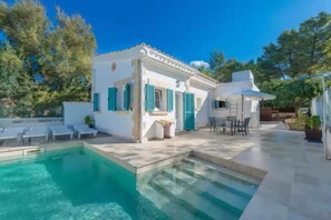 A poolside area with a pool, outdoor seating, and a white building with green shutters. - Villa Herdain - Villa With Private Pool. Free Wifi (Mal Pas - Bonaire (alcúdia), Illes Balears)