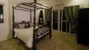 Una cama con dosel de madera oscura, suelo a cuadros y una ventana con cortinas.