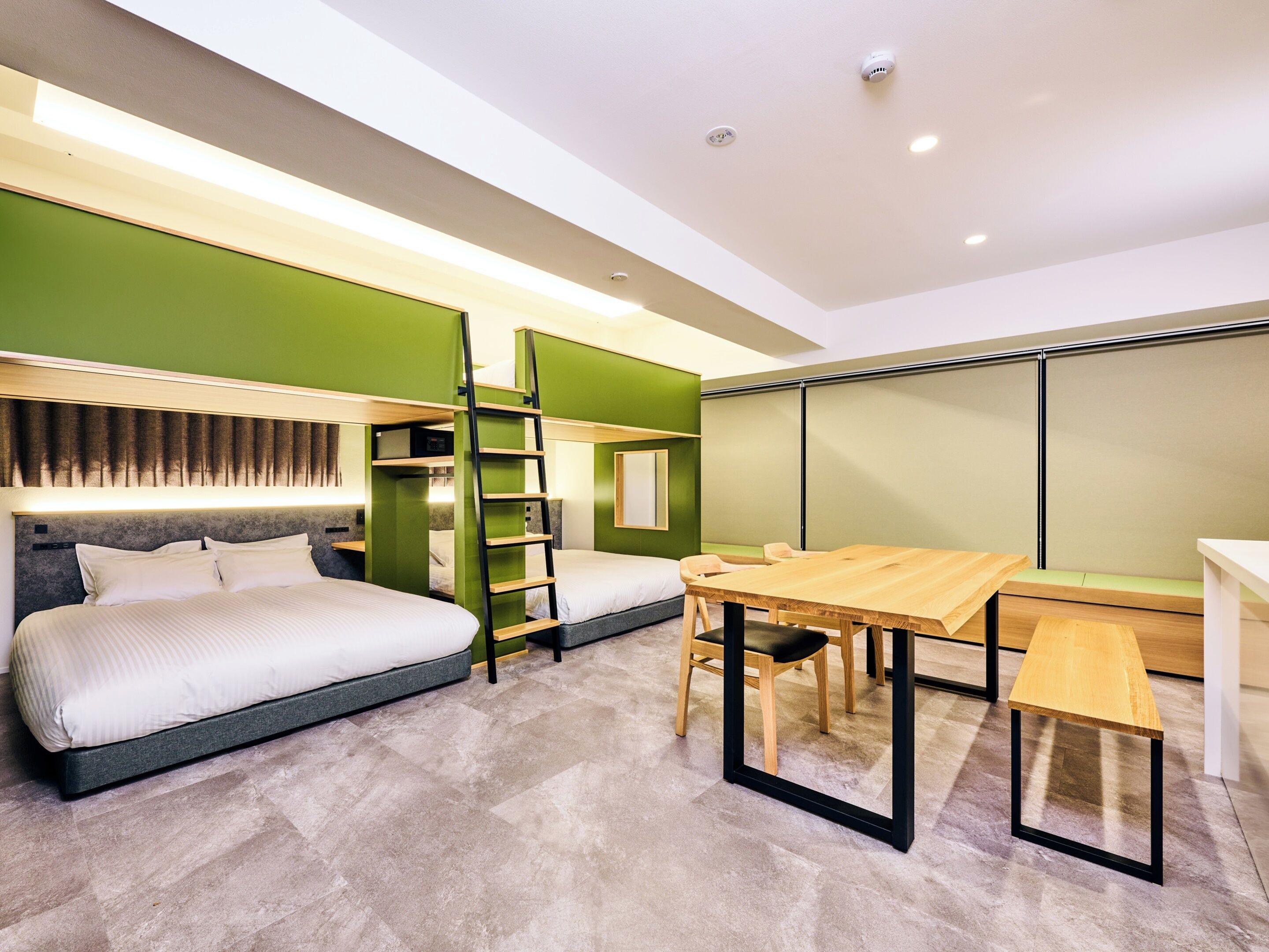 A modern hotel room with a bunk bed, a desk, and a chair.