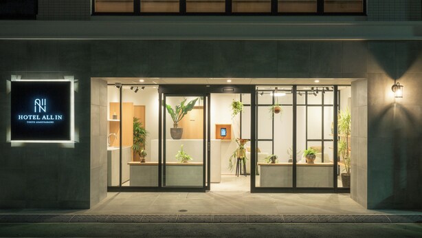 The exterior of Hotel All In, featuring a modern facade with large glass doors, indoor plants, and a prominent illuminated sign. - HOTEL ALL IN TOKYO ASAKUSABASHI (Tokyo)