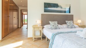 Een hotelkamer met een bed, nachtkastjes, een groot schilderij en een kledingkast.