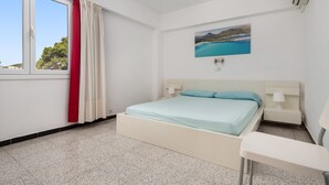 A bedroom with a bed, bedside tables, a window with curtains, and a wall-mounted air conditioner. - Mar Blava - Apartment In Cala Rajada. Free Wifi (Cala Rajada, Illes Balears)