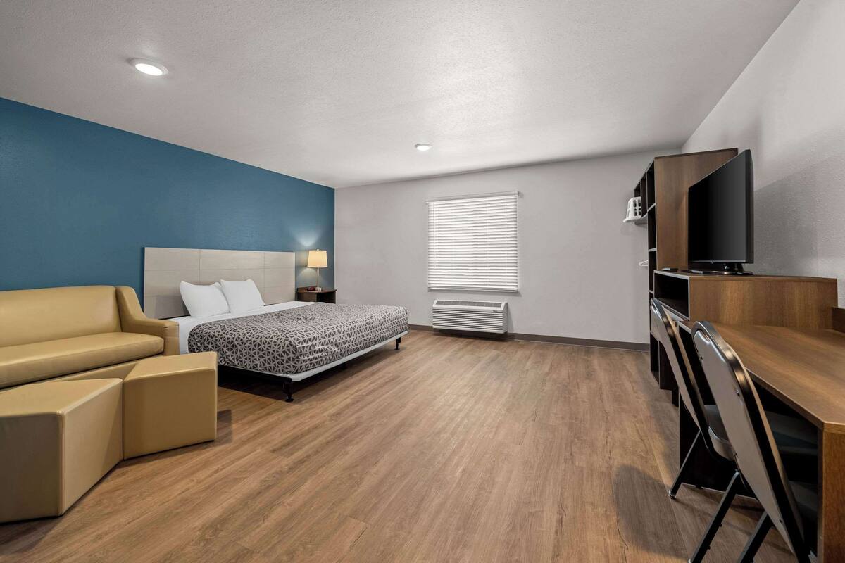 Une chambre d’hôtel moderne équipée d’un lit, d’un canapé, d’un bureau et d’une télévision.