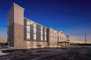 Un hotel de varios pisos con fachada de ladrillo, ventanas amplias y techo plano.