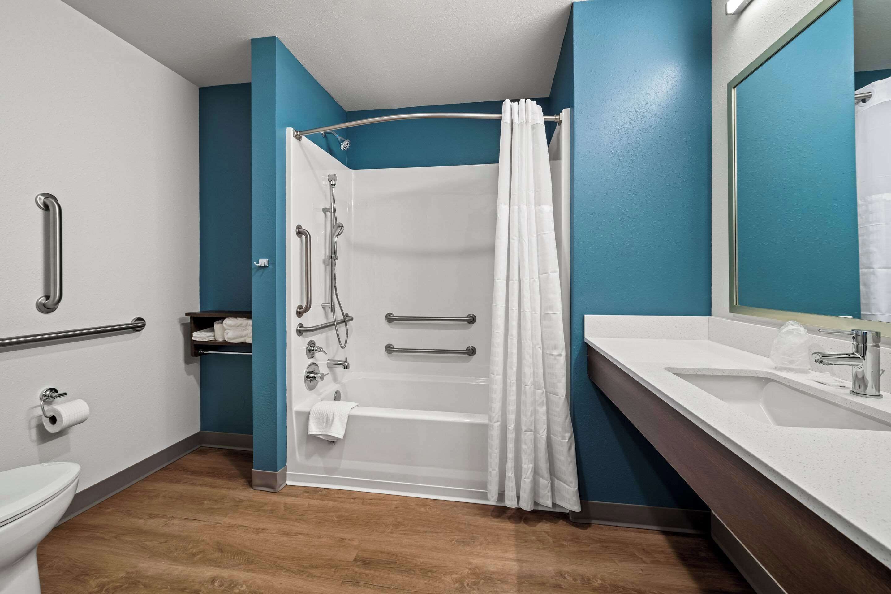 A modern bathroom with a shower, toilet, and sink.