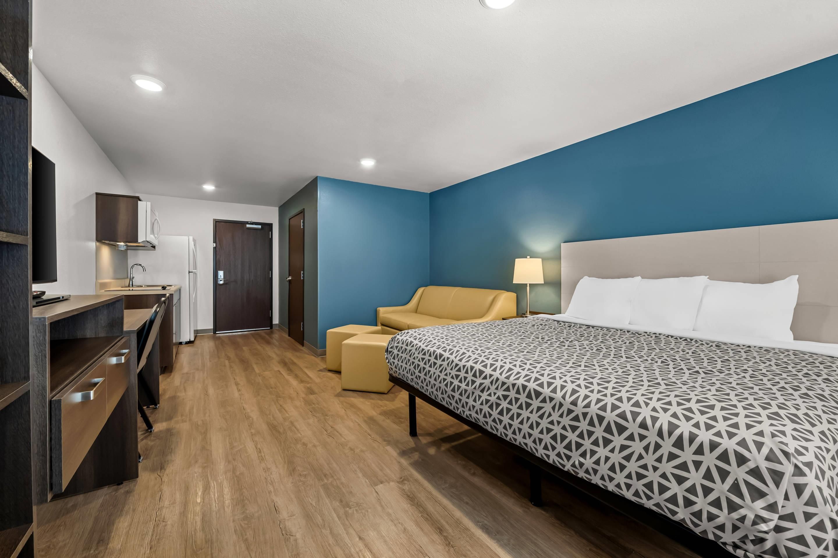 A hotel room with a bed, a desk, a chair, and a wardrobe.