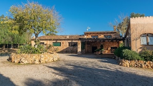 A rustic stone house with a courtyard, a stone wall, and a large tree. - Canaus - Villa With Private Pool In Porreres (Porreres, Illes Balears)