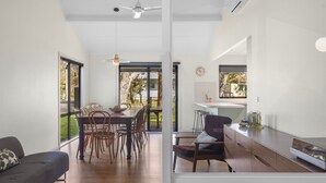 Una cocina moderna con comedor, ventanas amplias y un ventilador de techo.