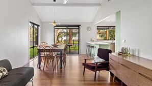Una cocina moderna con comedor, ventanas amplias y vistas al exterior.