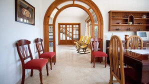 Un comedor con sillas de madera, una mesa y una estantería de madera.