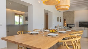 A modern dining area with a wooden table set for six, surrounded by wicker chairs. - Can Mosca - Villa With Private Pool. Free Wifi (, Illes Balears)
