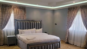 Un dormitorio moderno con una cama grande, una mesita de noche y un cabecero.