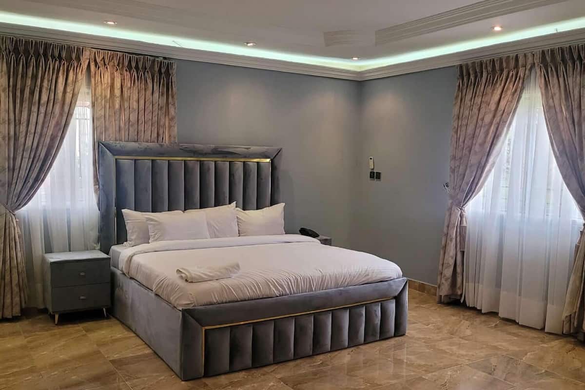 Una camera da letto moderna con un letto grande, un comodino e una testiera.