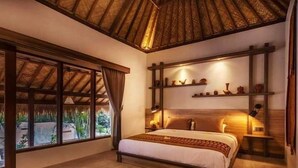 Une chambre à coucher avec un lit, une fenêtre et une étagère où sont disposés des objets décoratifs.