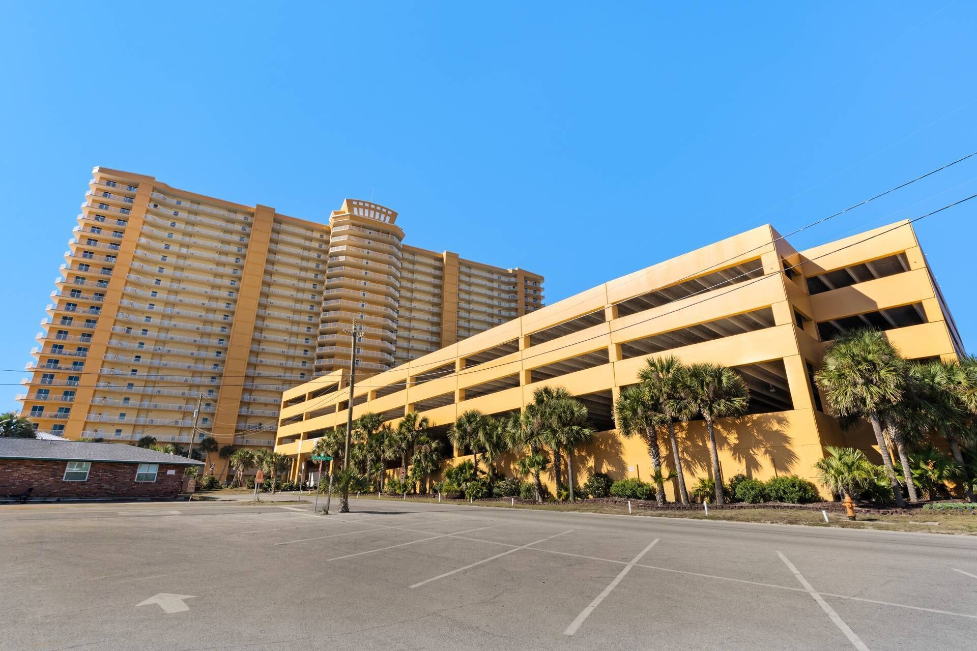 Un aparcamiento de varios niveles con un edificio residencial alto al fondo.