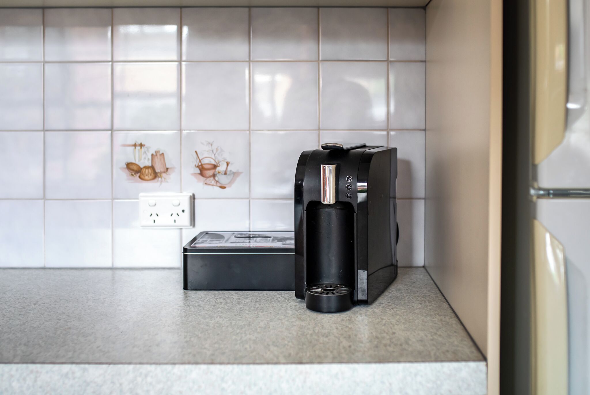 Una cocina con cafetera y regadera múltiple en la encimera.