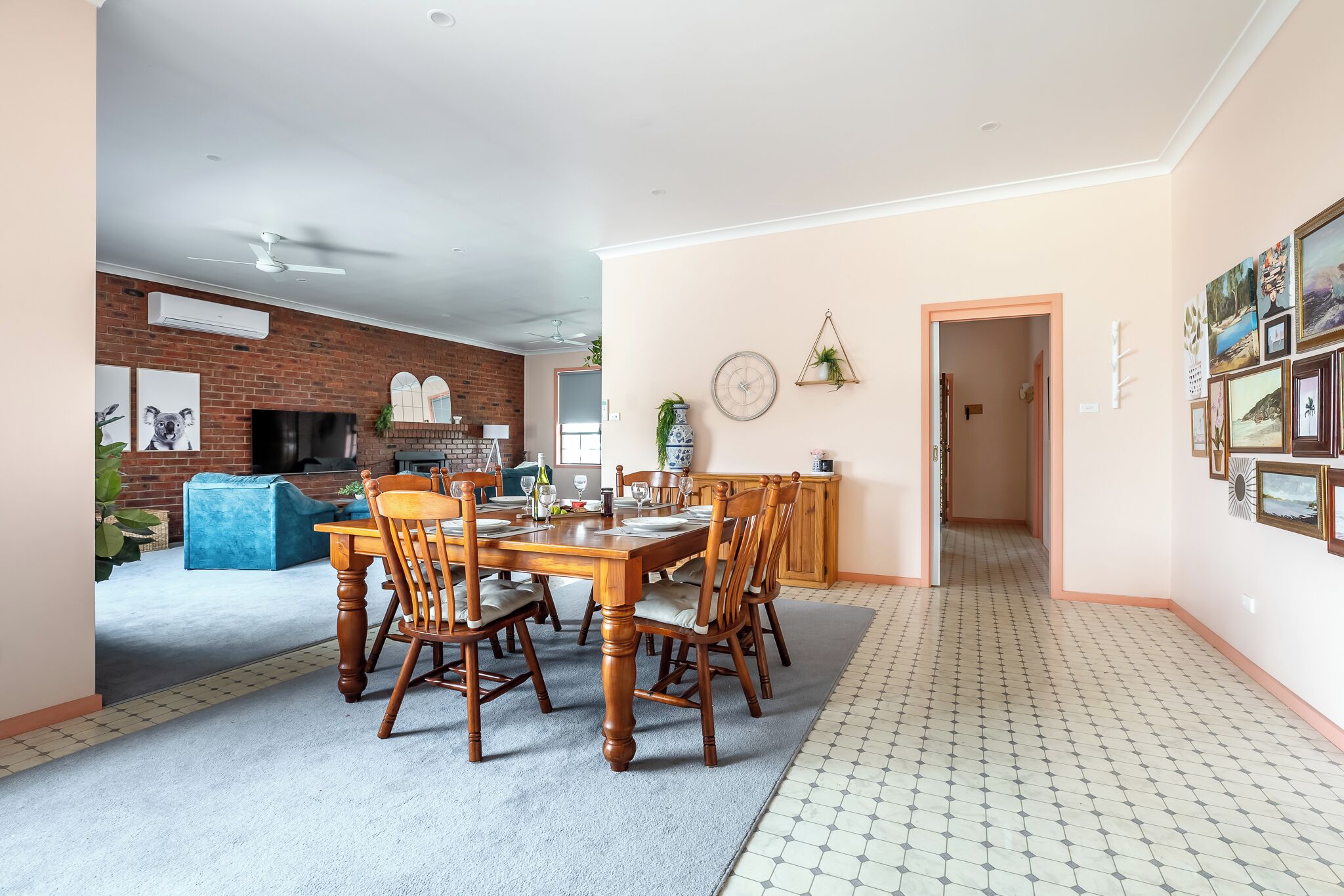 Un comedor con pared de ladrillo, chimenea y mesa dispuesta para seis comensales.