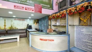 Zona de recepción con mostrador, asientos y una pared con carteles informativos.