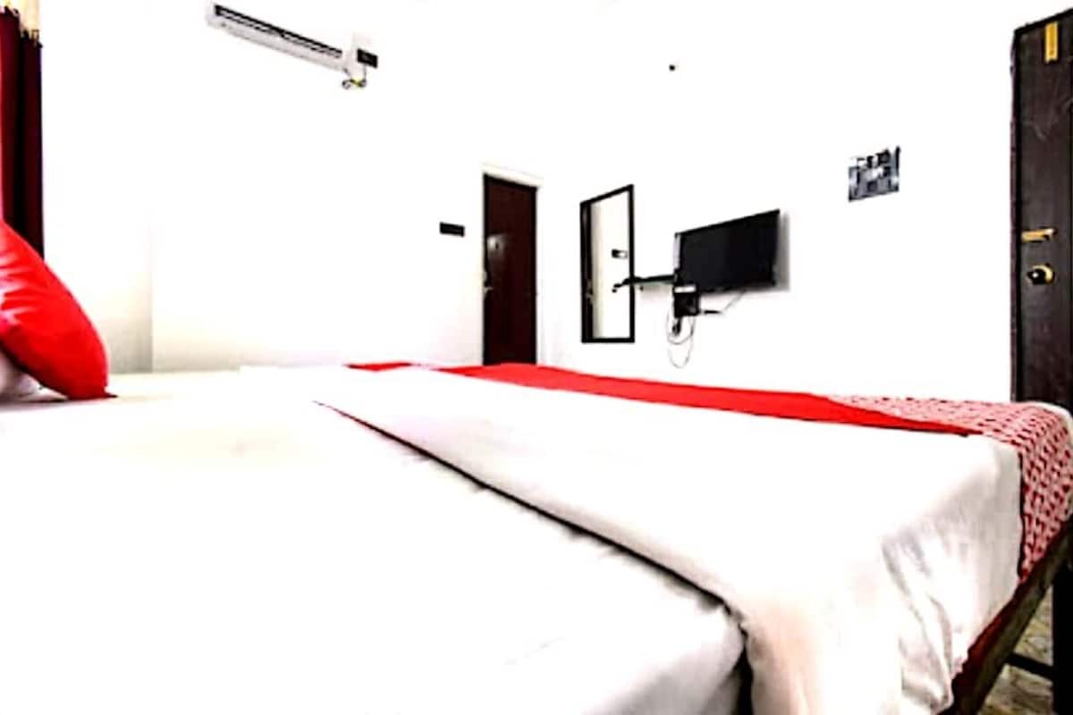 Ein Zimmer mit Bett, Kleiderschrank, Wand-Fernseher und Klimaanlage.