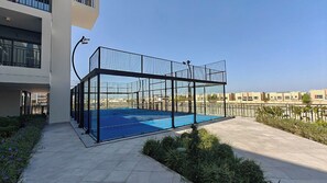 A rooftop swimming pool with a glass enclosure, surrounded by a metal fence and a landscaped garden. - TOP Location | Work and Chill near Miracle Garden (Dubai)