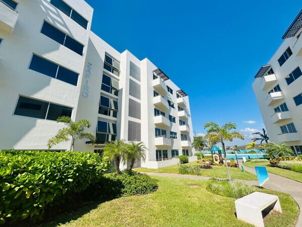 Un edificio moderno con varios balcones y una zona de piscina.