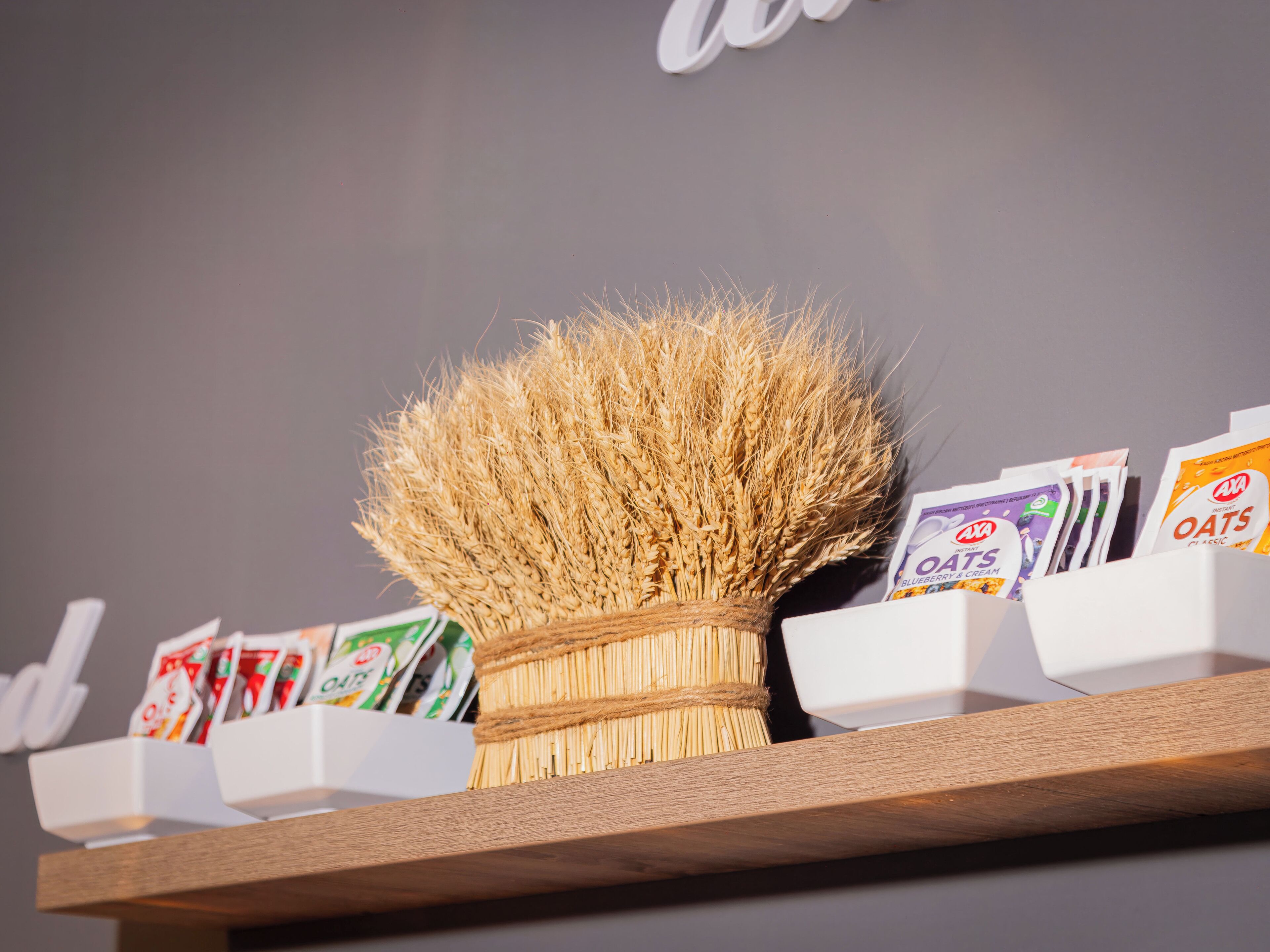 A shelf with oat packets and a wheat brush.