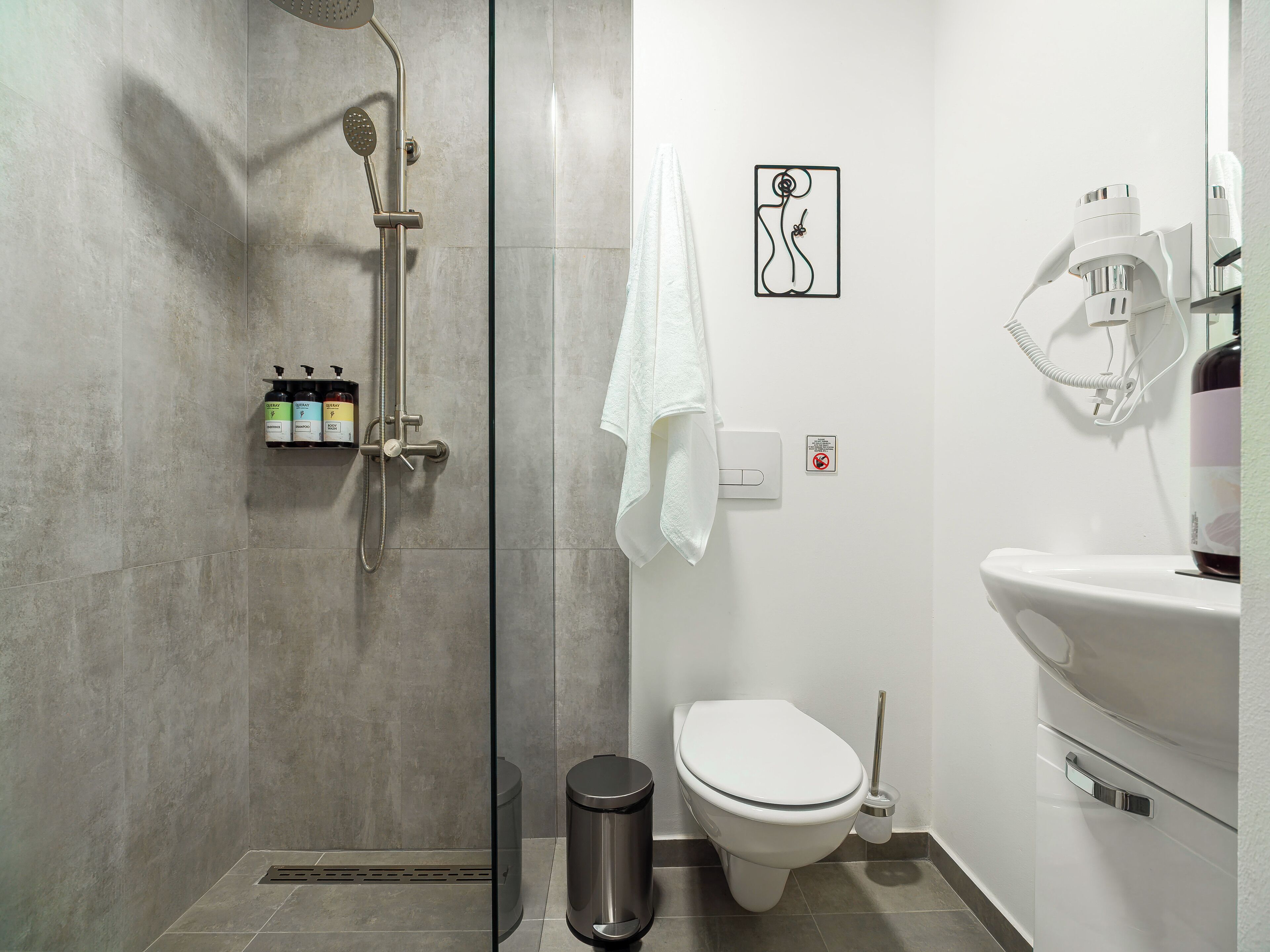 Un baño moderno con ducha, inodoro y lavamanos.