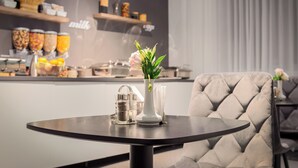 Un intérieur moderne avec une table ronde, un vase de fleurs et un fauteuil à capitonnage.