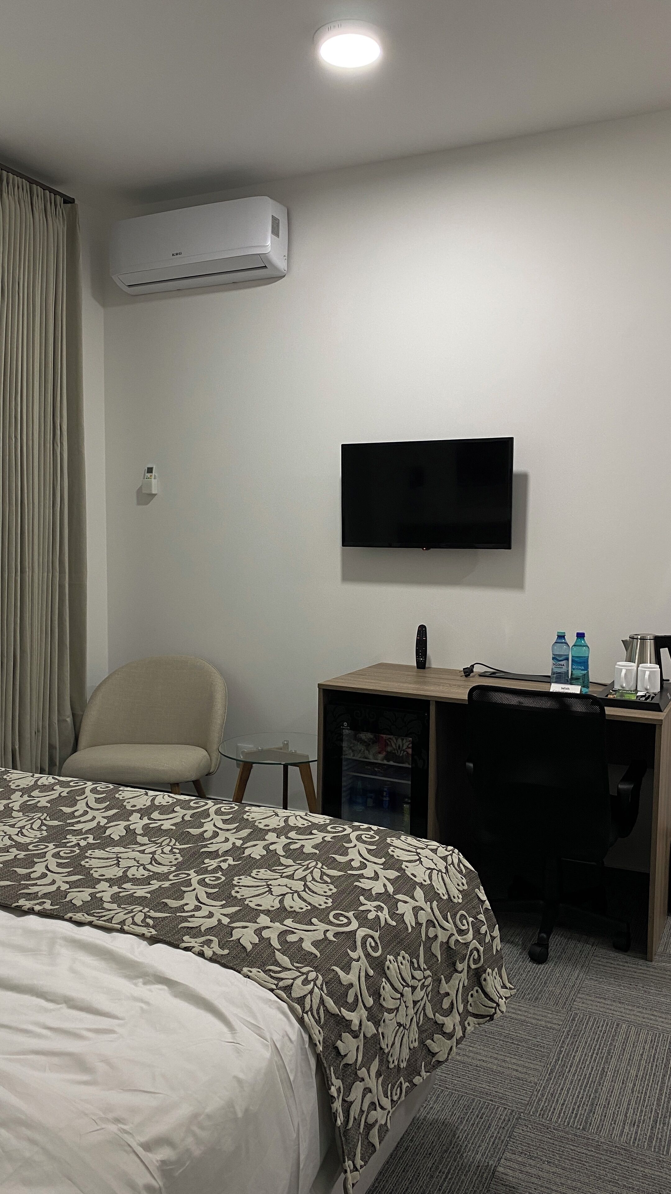 Une chambre d’hôtel équipée d’un lit, d’un bureau, d’une télévision et d’un appareil de climatisation.