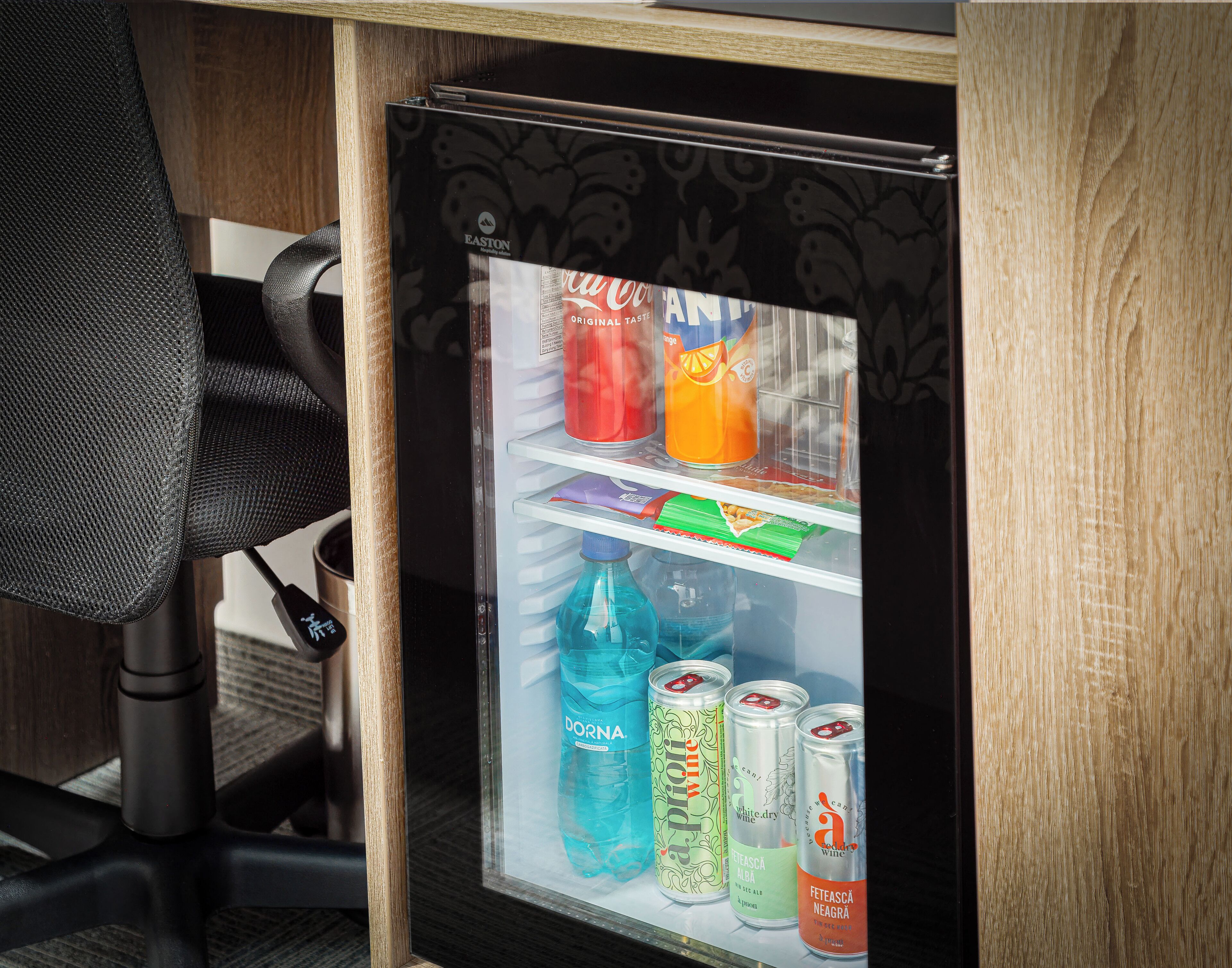 A mini-fridge with beverages and snacks.