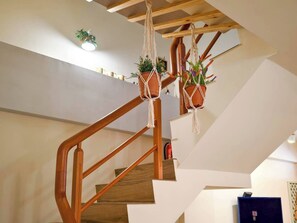 A staircase with wooden railings and macrame planters hanging from the ceiling. - TurnLeftHome (Wujie)