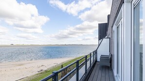 Un balcon avec vue sur une plage et la mer.