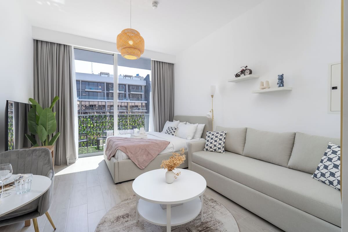 Un salon moderne comprenant un canapé, une table basse et un coin repas avec une chaise et une table.