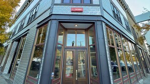 Een hoekgebouw met een 'GEEN VAKANTIE' bord, grote ramen en een 'HOTEL' bord boven de ingang.