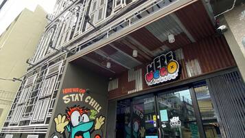 A building with a mural of a cartoon character and the text "HERE WE GO STAY CHILL".
