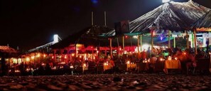 A beachside restaurant with outdoor seating and a thatched roof structure. - Mafalda - Luxury Apartments & Suites (Calangute)
