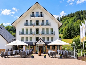 A hotel with a two-story balcony, outdoor seating area, and a sign indicating it is a smart resort. - A comfortable and versatile room—perfect for relaxation, work, and socializing (Winterberg)