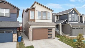 A residential area with modern houses, a driveway, and a small lawn. - Perfect 2BR Airdrie Suite - Near Calgary, WiFi (Airdrie)