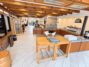 A spacious kitchen with wooden beams, a central island, and a view into the dining area. - Comfortable and versatile room -perfect for relaxation, work and exchange (Winterberg)