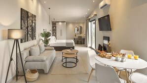 Une chambre d’hôtel moderne équipée d’un lit, d’un canapé, d’une table à manger et d’un téléviseur.